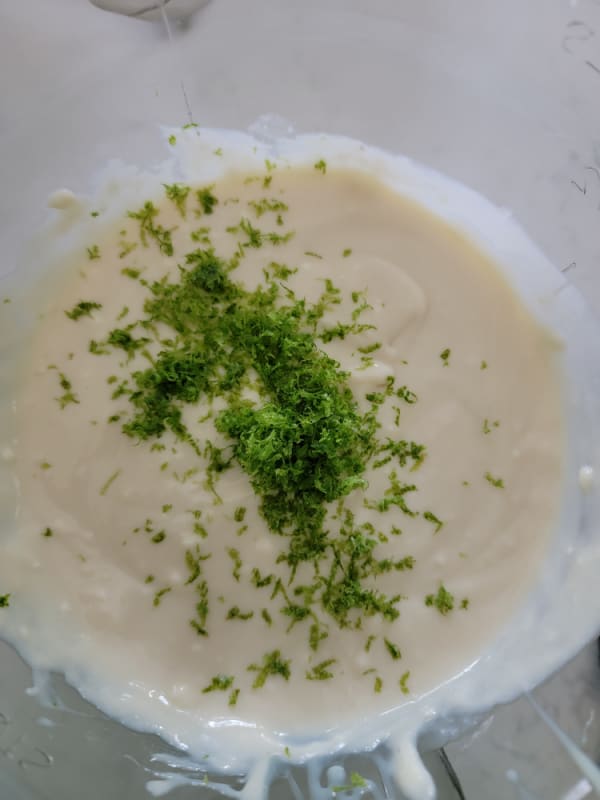 lime zest over batter in a glass mixing bowl 