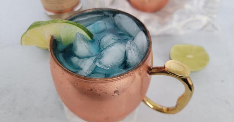 Blue Moscow Mule in a copper mug with a lime wedge