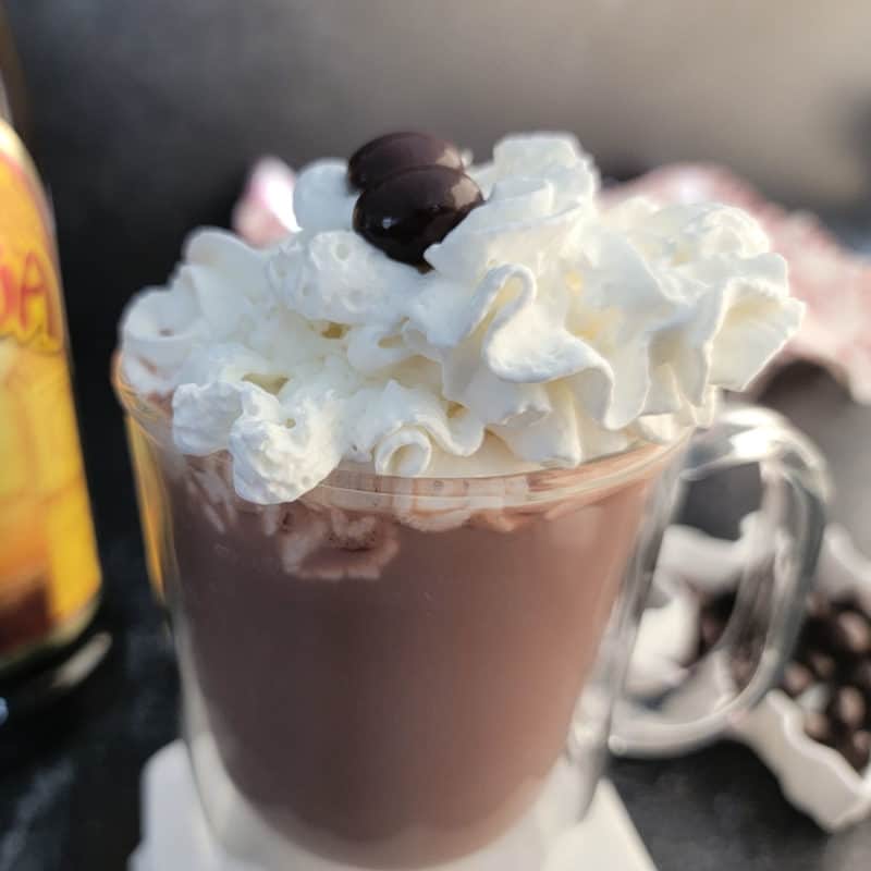 Kahlua Hot Chocolate in a glass coffee mug garnished with whipped cream and espresso beans