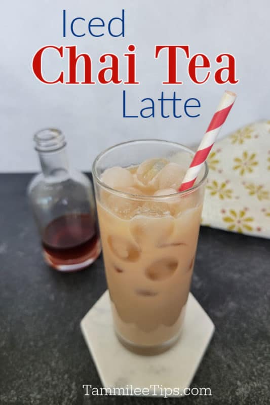 Iced Chai Tea latte over a glass with chai tea, a striped straw, and a bottle of chai syrup 