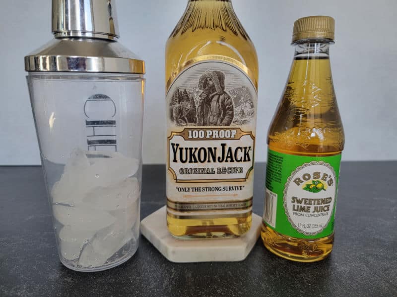 Cocktail shaker with ice, 100 proof Yukon Jack and Rose's Sweetened Lime Juice Bottle