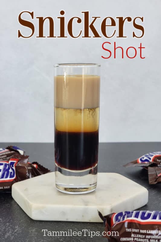 Snickers Shot text over a layered snickers shot on a coaster with Snickers Candy Bars