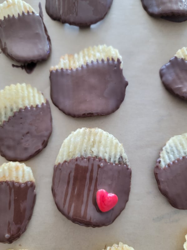 Chocolate dipped ruffles potato chips on parchment paper