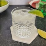 Tequila and Sprite cocktail in a rocks glass with lime garnish