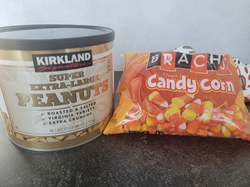 Large can of peanuts next to a bag of classic candy corn