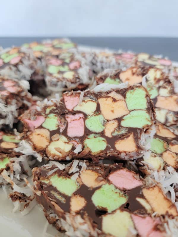 slices of no bake church window cookies with rainbow marshmallows on a white platter