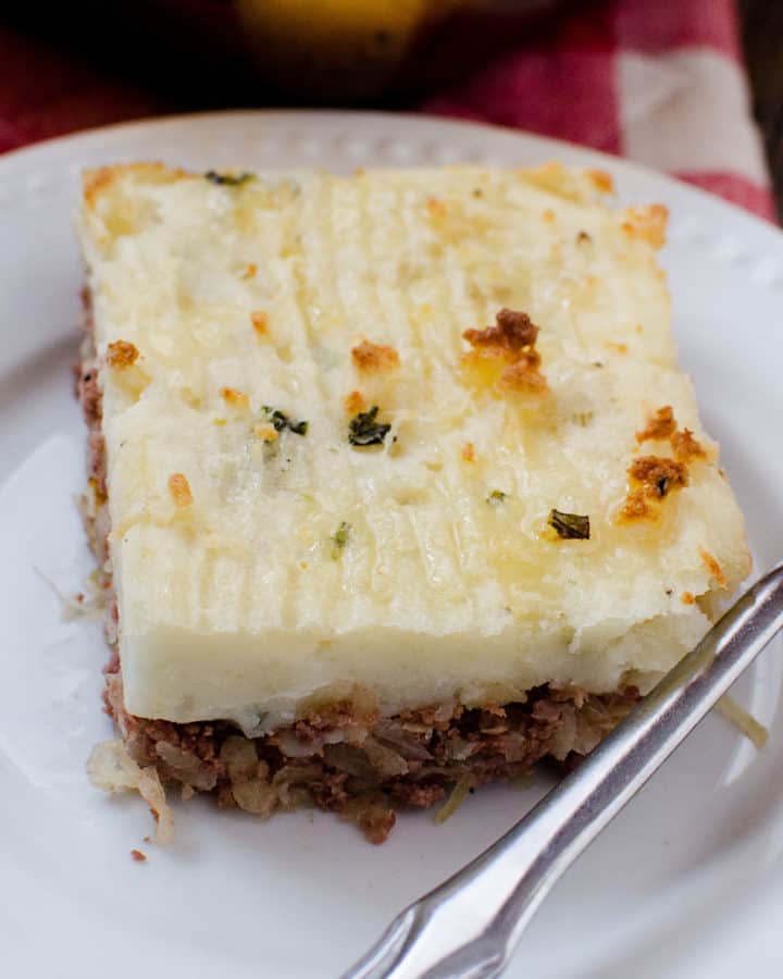 Corned Beef Shepherd's Pie on a white plate with a silver fork