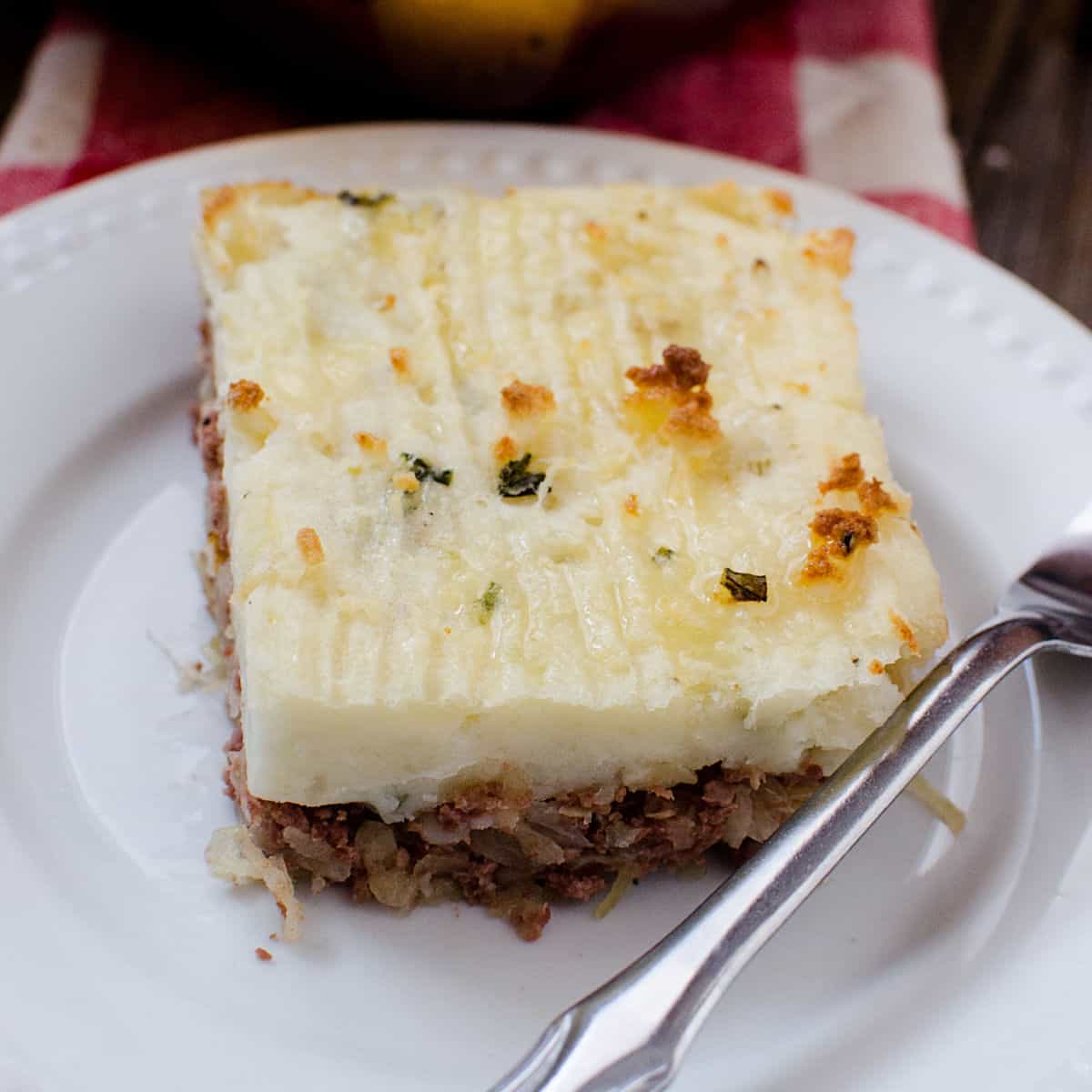 Corned Beef Shepherd's Pie on a white plate with a silver fork