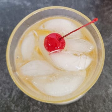 Fireball ginger ale cocktail with maraschino cherry garnish