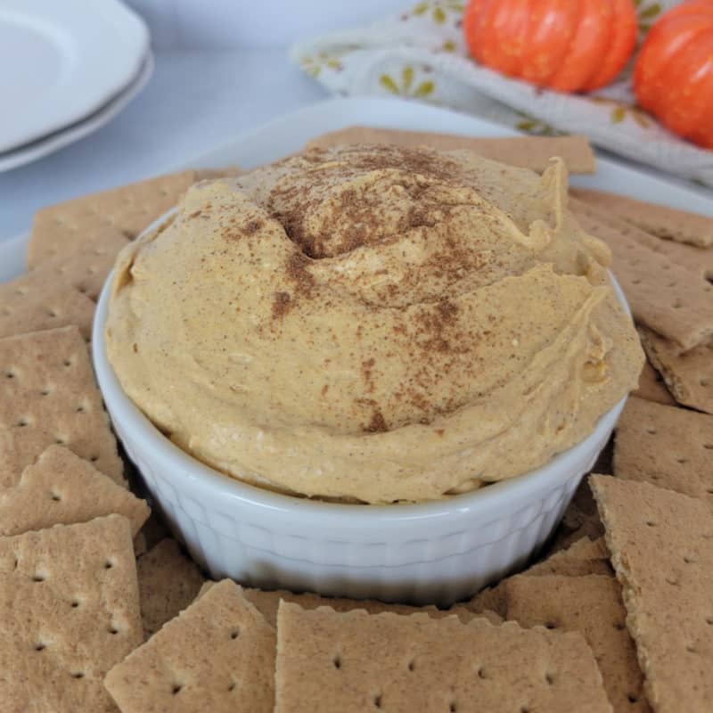 Pumpkin Cream Cheese Dip in a white bowl surrounded by graham crackers