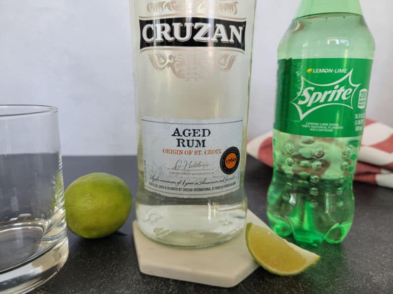 Cocktail glass, Lime, Cruzan aged rum bottle, and a bottle of sprite