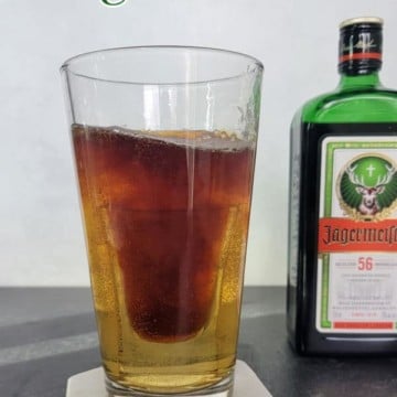 Jager Bomb text over a glass with a shot of jagermeister in it next to a bottle of jagermeister