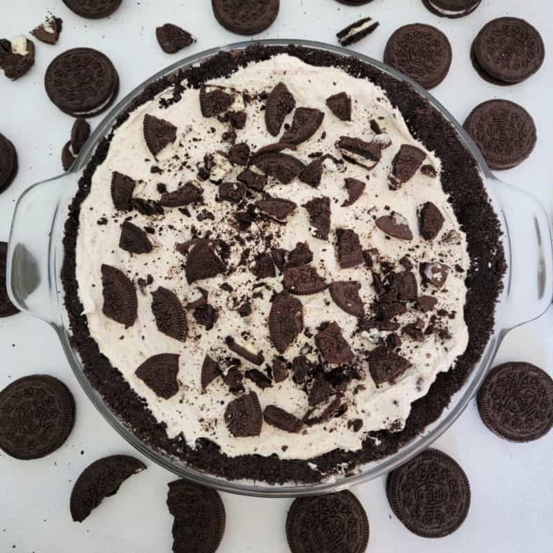No bake Oreo cheesecake in a glass dish surrounded by Oreo Cookies