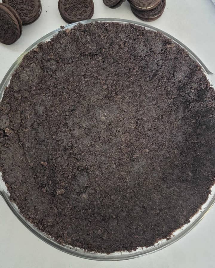 Oreo Crust in a pie dish surrounded by Oreo Cookies