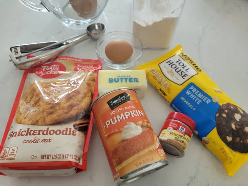 Pumpkin Snickerdoodle ingredients - snickerdoodle cookie mix, canned pumpkin, egg, butter, pumpkin pie spice, chocolate chips, flour, and a cookie scoop