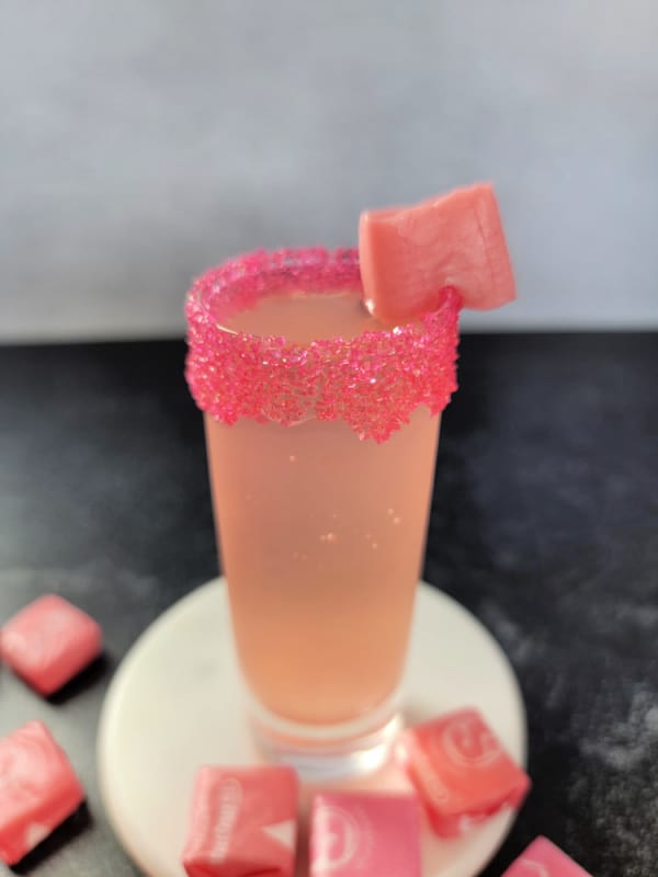 Pink starburst shot garnished with pink sprinkles and a pink starburst 