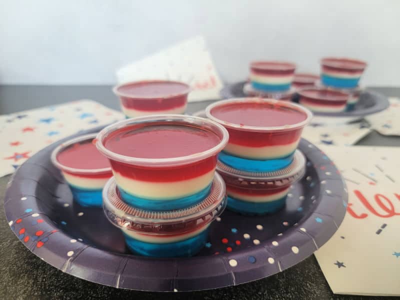 Red White and Blue Jello Shots on a blue plate next to star napkins