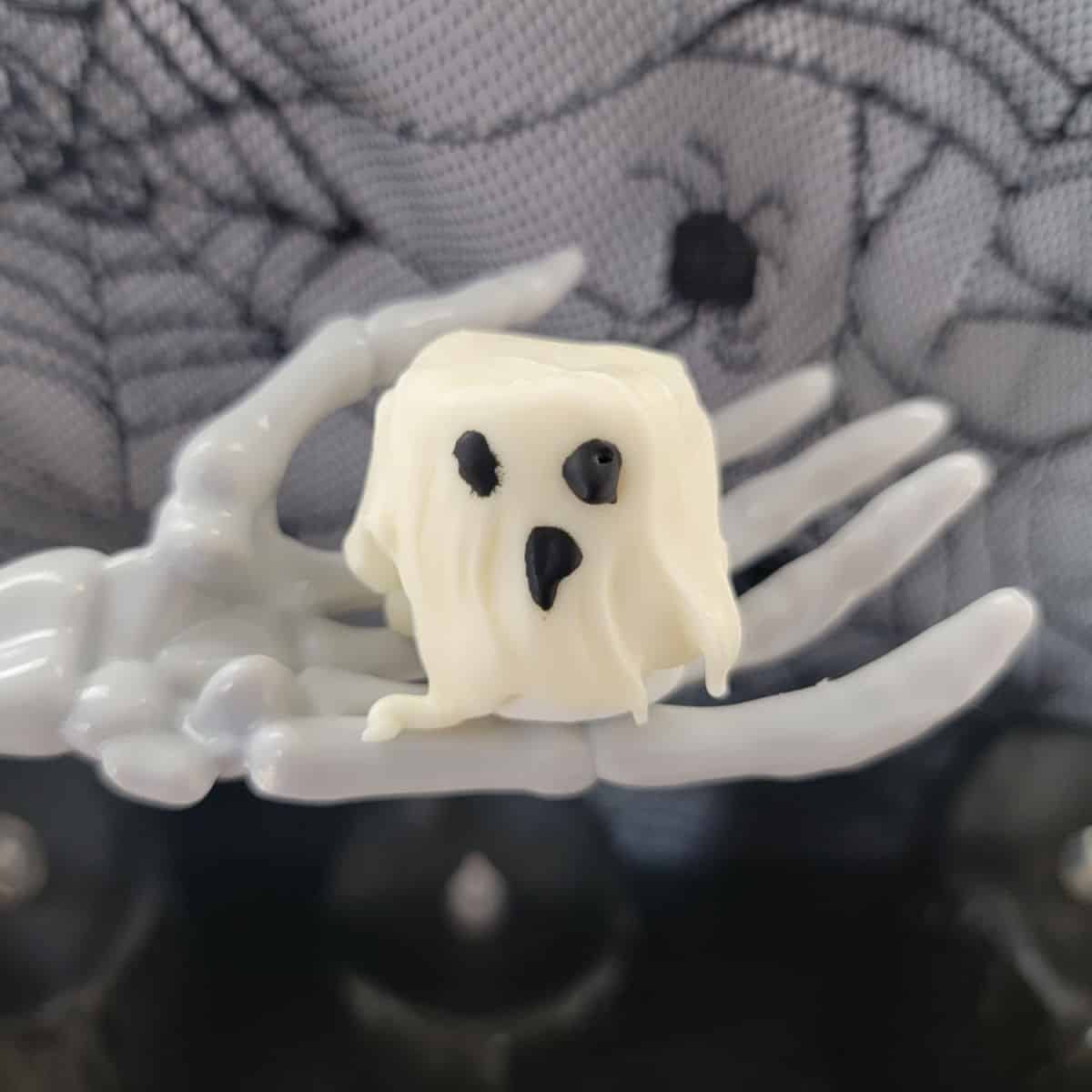 Marshmallow Ghost sitting on a skeleton hand