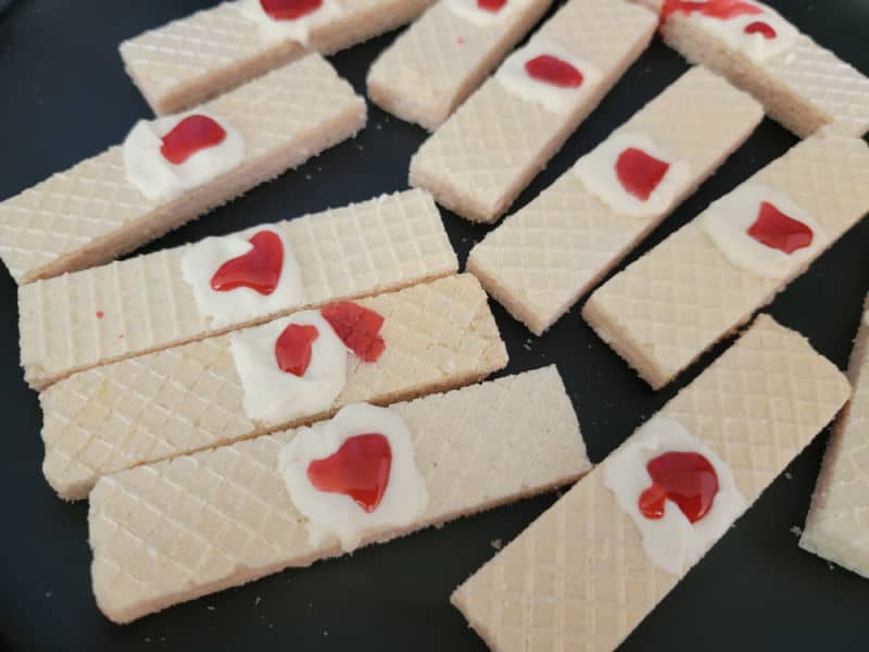 edible blood on white icing on a vanilla wafer for bloody bandages