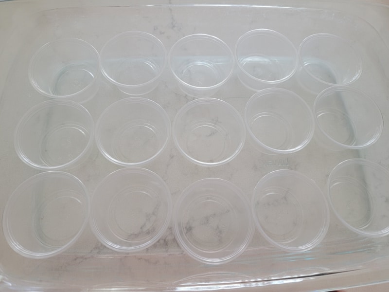 empty Plastic jello shot cups in a baking dish