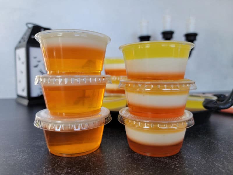 Two different layered Candy Corn Jello Shots in a stack next to each other