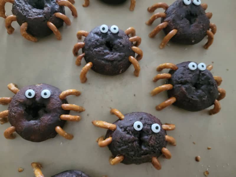 Spider donuts spread over parchment paper 