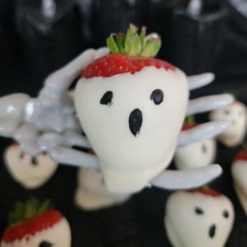 Strawberry Ghost being held by a skeleton hand