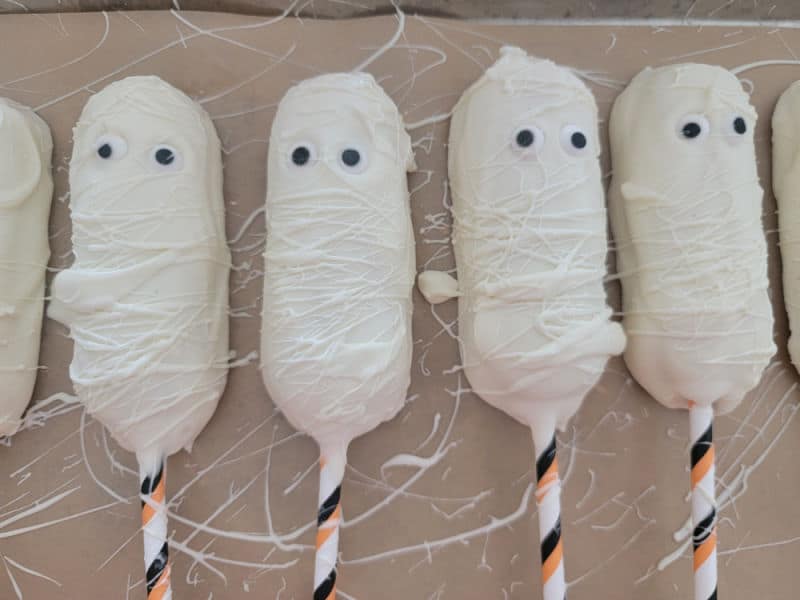 Mummy Twinkies lined up on parchment paper 