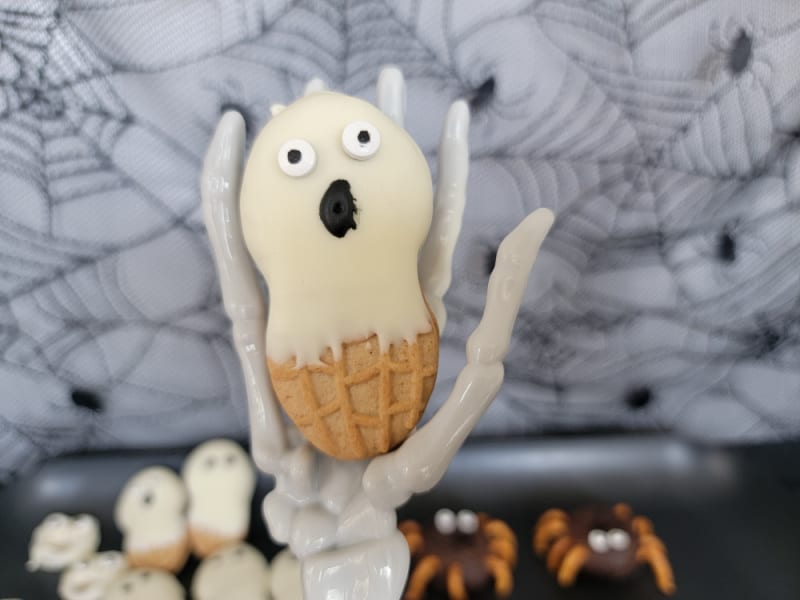 Nutter butter ghost held by a skeleton hand