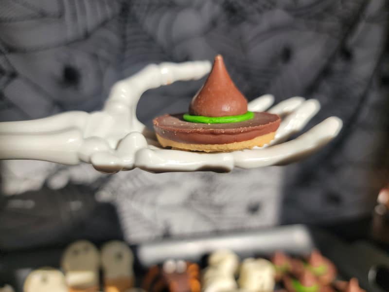 witches hat cookie held by a skeleton hand