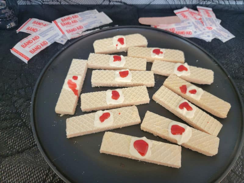 bloody bandages on vanilla wafers on a black plate