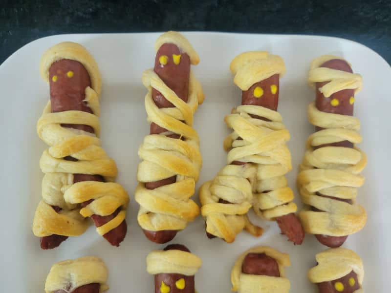 Mummy hot dogs on a white plate