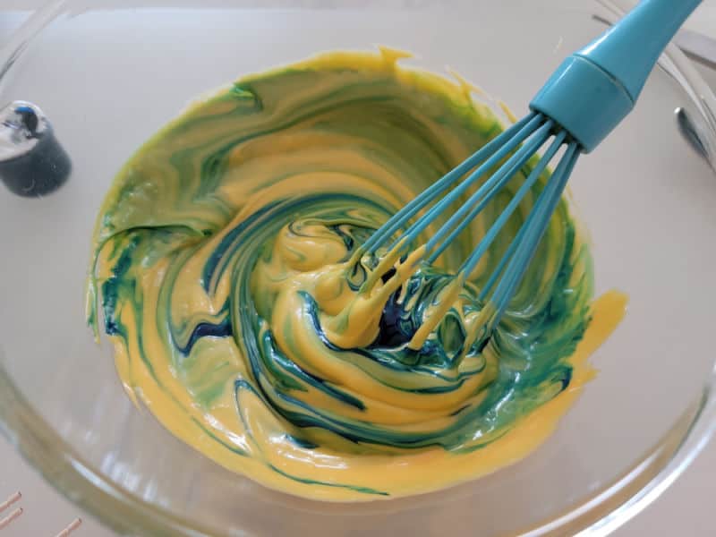 Blue food coloring mixing into cheese sauce
