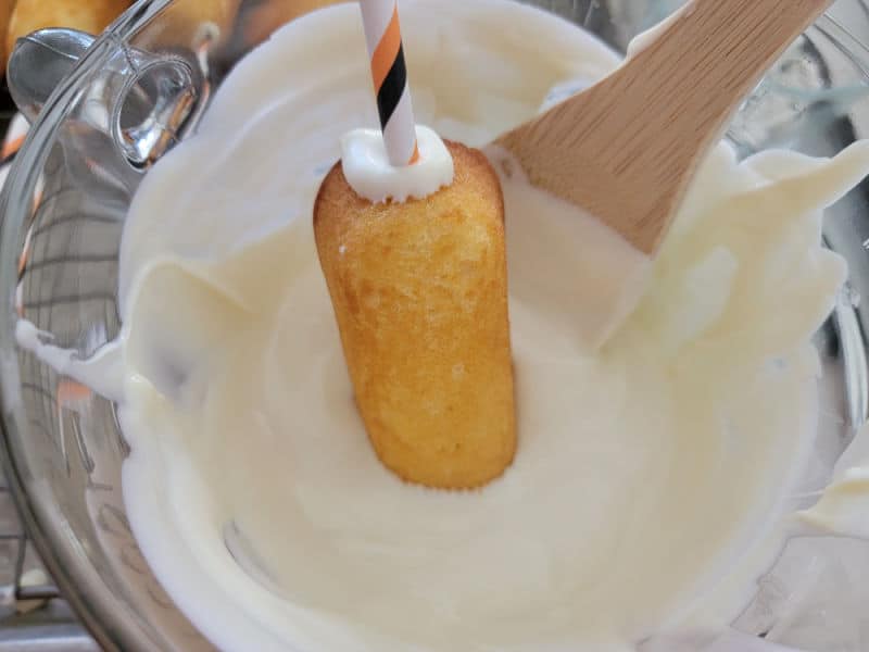 Twinkies dipping into melted vanilla bark