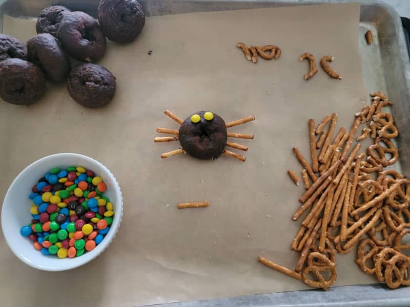 Spider doughnut with pretzel pieces, M&Ms, an other doughnuts