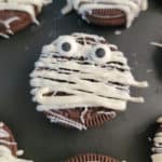 Mummy Oreo with candy eyes on a black plate