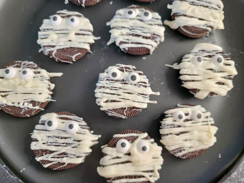 Oreo Mummy Cookies on a round black plate