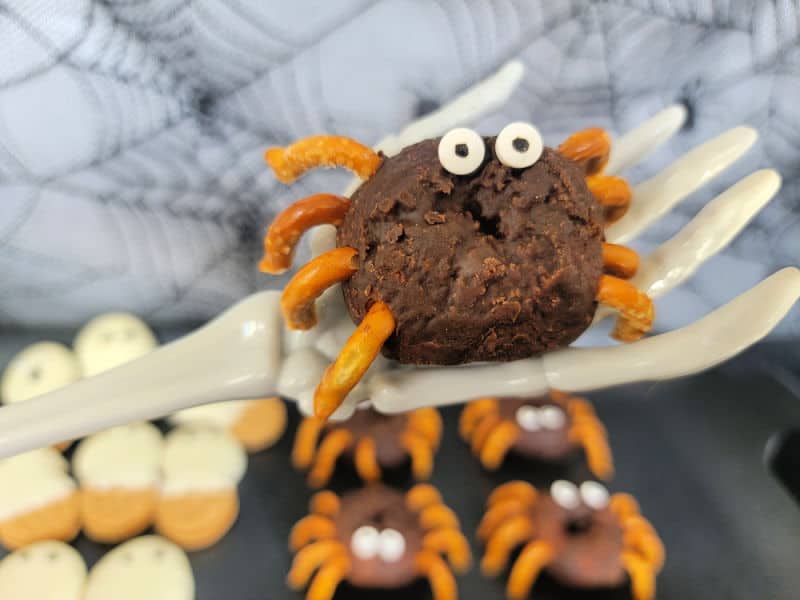 Spider donut held on a skeleton hand