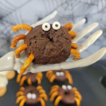 Spider Donut held by a skeleton hand