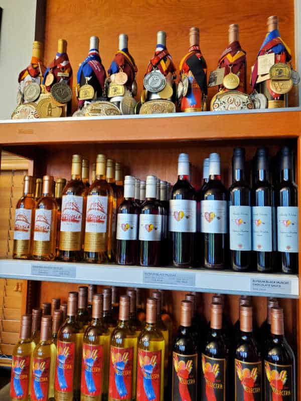 Rows of Quady Wine on 3 shelfs some with award medals