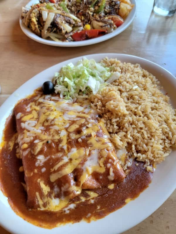 cheese enchiladas with rice on a white plate at El Cid in Oakhurst