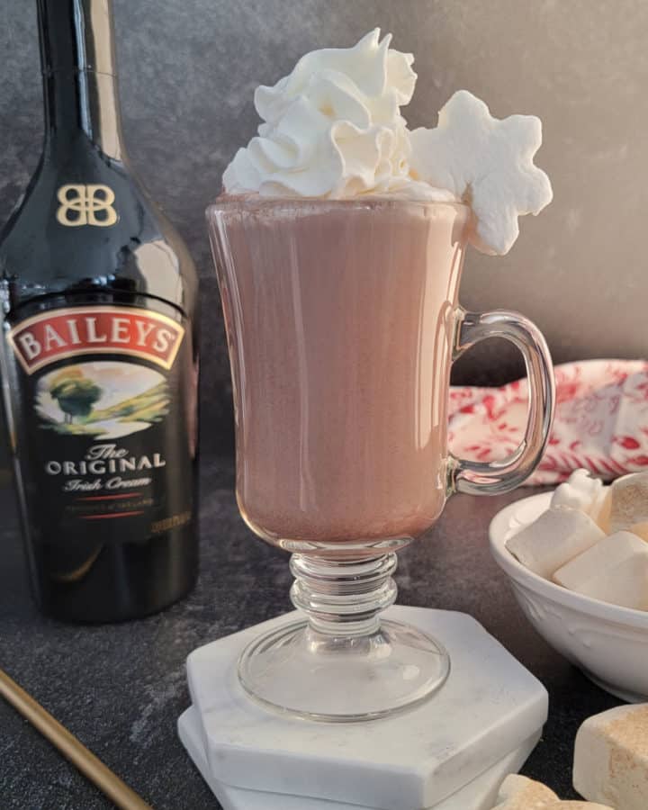 Baileys Hot Chocolate in a glass mug with whipped cream and a snowflake marshmallow