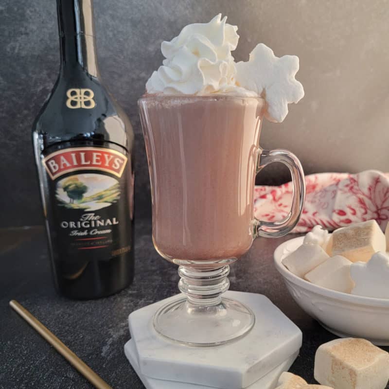 Baileys Hot Chocolate in a glass mug with whipped cream and a snowflake marshmallow