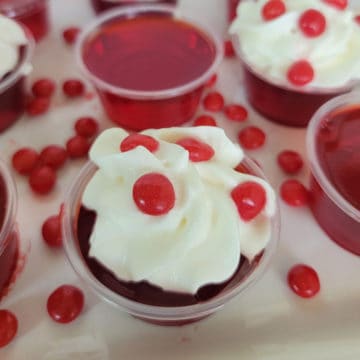 Fireball Jello Shot with whipped cream and a red hot candy on a white plate