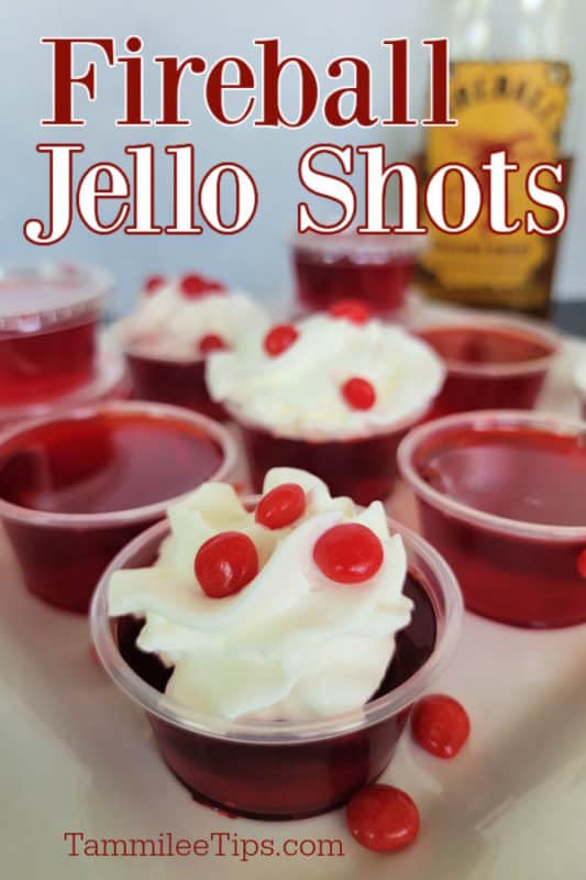 Fireball Jello Shots text over red jello shots garnished with whipped cream and a bottle of Fireball