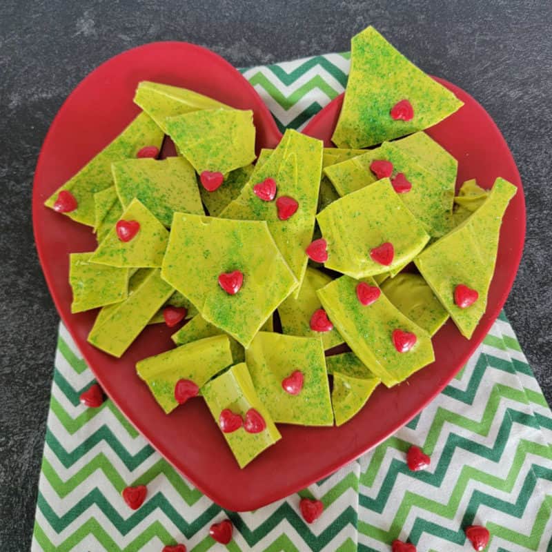 green grinch bark on a red heart plate with a green napkin
