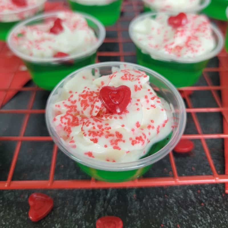 Green grinch jello shot with red heart on a red drying rack