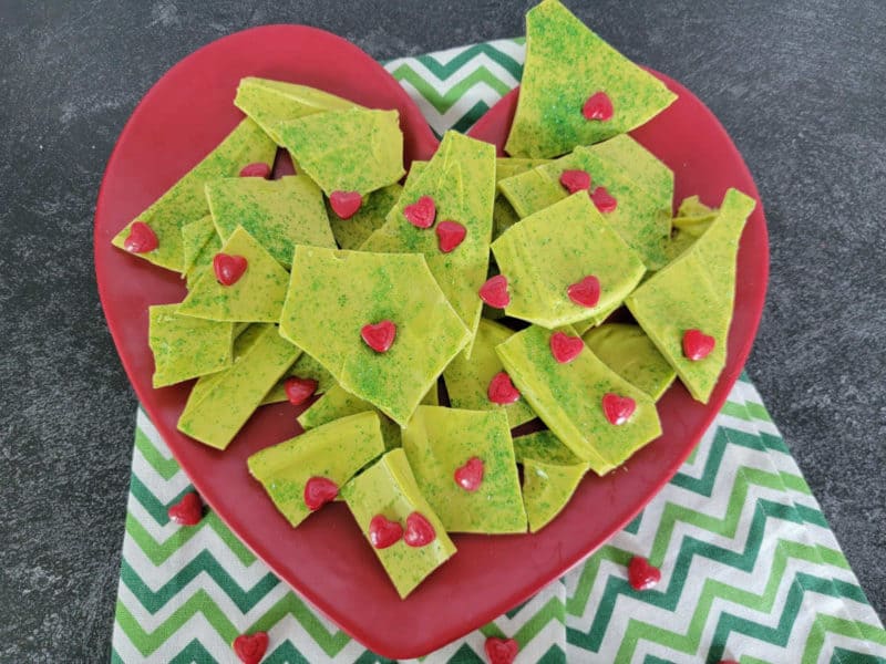 Homemade Grinch Bark on a red plate with a green napkin