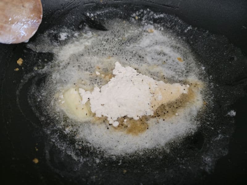 flour and seasoning in bubbling butter for cheesy green beans sauce