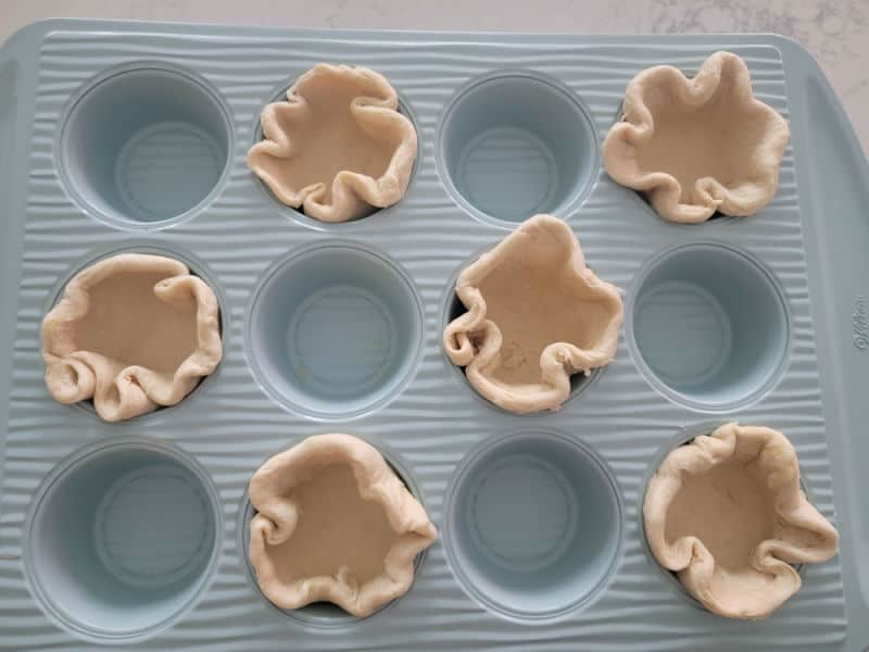 Refrigerator biscuit dough in a muffin tin to create biscuit cups 